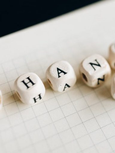 Close-up of letter dice spelling 'change' on a grid notepad, symbolizing transformation.
