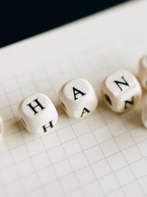 Close-up of letter dice spelling 'change' on a grid notepad, symbolizing transformation.